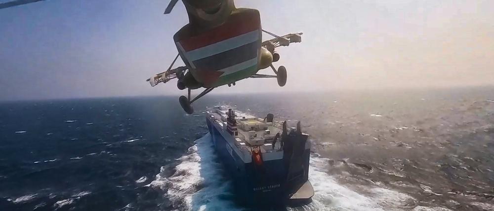 Ein Huthi-Hubschrauber fliegt am 19.11.2023 über das Frachtschiff „Galaxy Leader“.