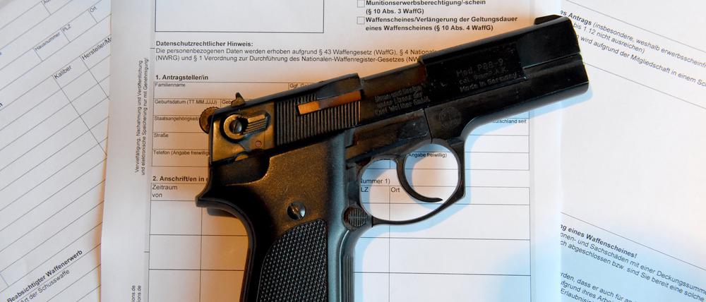 Eine Pistole liegt auf einem Antrag für die Ausstellung eines Waffenscheines.