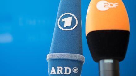 Die Mikrofone von ARD und ZDF sind vor einer Pressekonferenz nebeneinander aufgestellt. 