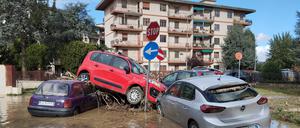 04.11.2023, Italien, Campi Bisenzio: Von den Wassermassen eines Unwetters übereinandergetürmt liegen Autos in den immer noch überfluteten Straßen. 