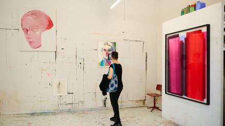 Frauen-Porträts der Künstlerin Tina Berning neben einem Werk von Julio Rondo im Open Studio, der Werkstatt der Künstlerin. 