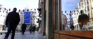 Ein Mann geht unter den Flaggen der Europäischen Union in einer der Hauptstraßen von Sarajevo.