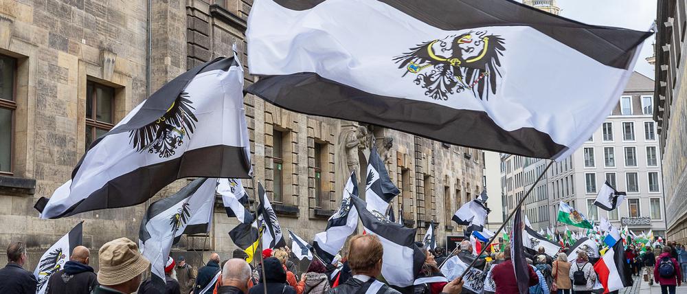 Mehrere Hundert Teilnehmer einer Demonstration ziehen mit Flaggen vom Königreich Preußen (schwarz-weiß-schwarz mit Adler) durch die Dresdner Innenstadt. (Archivbild)