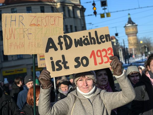 Eine Demonstrationsteilnehmerin hält in Halle (Saale) ein Schild mit der Aufschrift „AfD wählen ist so 1933“ in die Höhe.