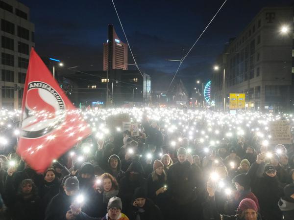 Teilnehmer einer Kundgebung versammeln sich am Sonntag auf dem Johannisplatz in Leipzig und leuchten mit ihren Telefonen.