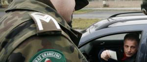 Polnischer Grenzpolizist kontrolliert einen Wagen.