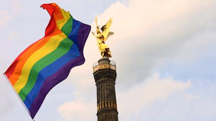 Eine Regenbogenfahne vor der Siegessäule in Berlin.
