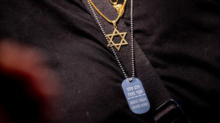 
Eine Frau trägt das Davidstern-Symbol und eine weitere Halskette mit der Aufschrift „Bring Them Home Now!“ während einer Kundgebung gegen den Antisemitismus auf dem Campus der George Washington University