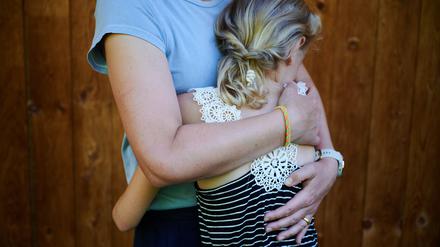 Eine Mutter umarmt ihr Kind.