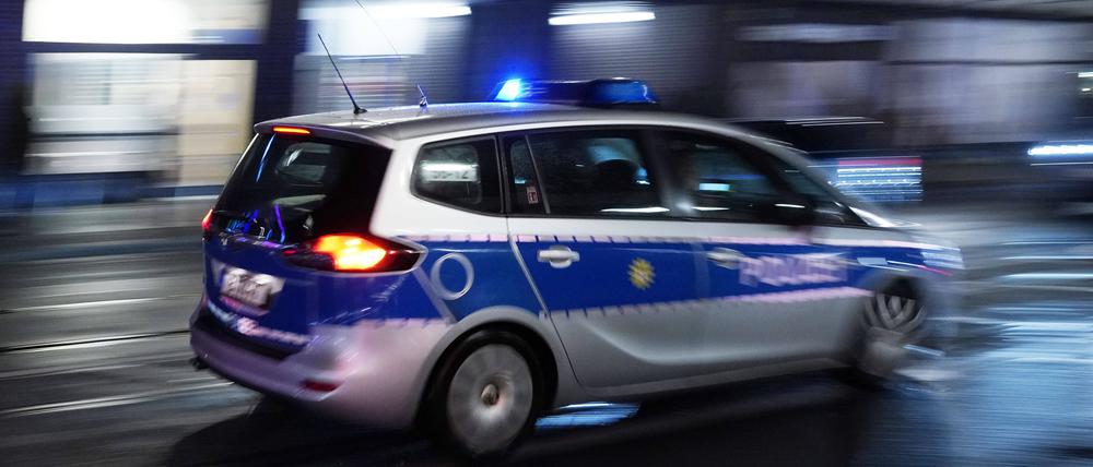 Ein Polizeiauto bei einer Einsatzfahrt mit Blaulicht (Symbolbild).