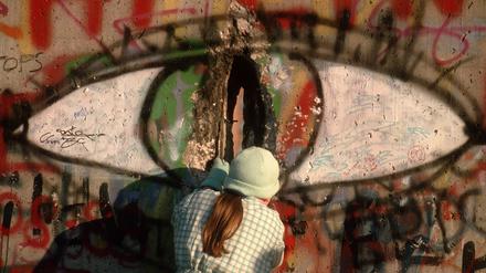 Eine Frau meisselt ein Stück Stein als Andenken aus der Berliner Mauer. Berlin, 09.11.1989.