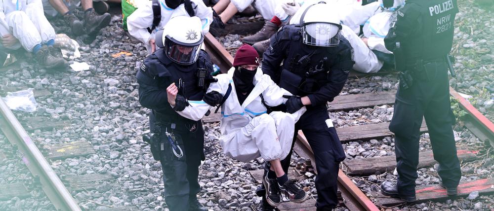 Ein Klimaschutzaktivist der Gruppe „Ende Gelände“ wird vor dem Kraftwerk Scholven von Polizisten weggetragen.
