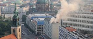 Rauch steigt aus einem Hochhaus, im Hintergrund der Berliner Dom. In einem Hochhaus in der Nähe des Berliner Alexanderplatzes ist am Dienstagabend ein Feuer ausgebrochen. 