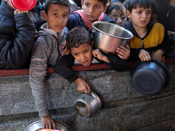 In Rafah warten palästinensische Kinder auf Essen. 