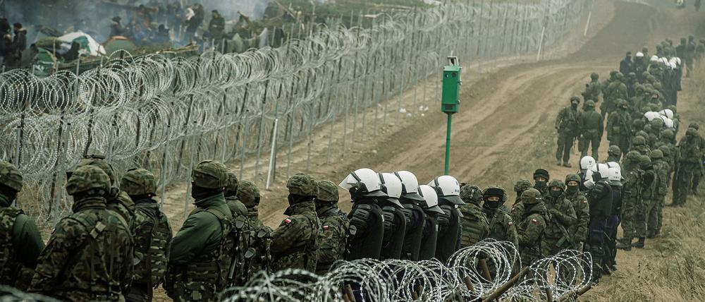 Martialisch abgegrenzt. Polnische Soldaten und Polizisten bewachen die Grenze zu Belarus.