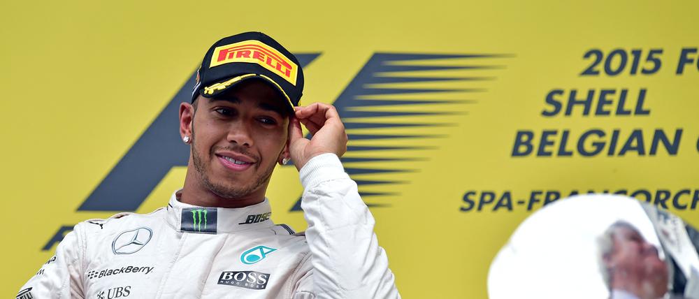 (FILES) Mercedes AMG Petronas F1 Team's British driver Lewis Hamilton looks at the trophy as he celebrates winning on the podium at the Spa-Francorchamps circuit in Spa on August 23, 2015, after the Belgian Formula One Grand Prix. Seven-time Formula One world champion Lewis Hamilton will leave Mercedes at the end of the 2024 season, the team announced February 1, 2024, ahead of an expected move to Ferrari for 2025 season. "Lewis has activated a release option in the contract announced last August and this season will therefore be his last driving for the Silver Arrows," Mercedes said in a statement. (Photo by ANDREJ ISAKOVIC / AFP)