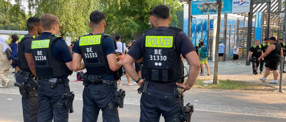 Polizisten stehen am 09.07.2023 vor dem Eingang des Sommerbad in Neukölln.