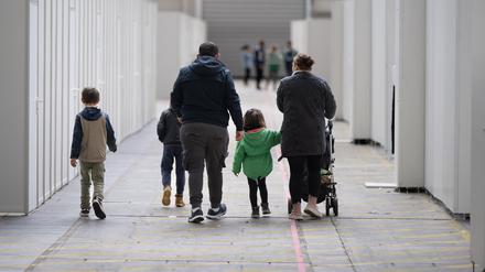 Eine Flüchtlingsfamilie geht durch die zu einer Massenunterkunft umfunktionierten Messehalle in Frankfurt.