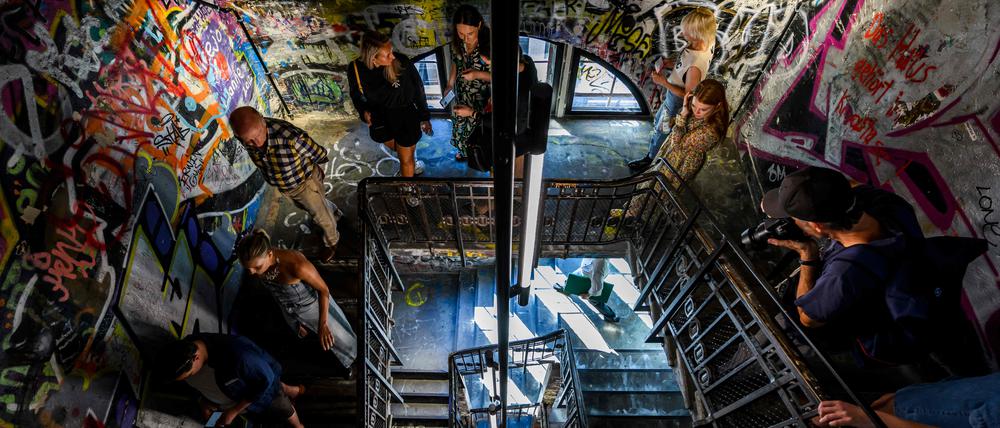 Visitors walk down a stairwell decorated with graffiti during a press preview at the Fotografiska photography museum, housed in the former art squat "Kunsthaus Tacheles" in Berlin on September 7, 2023. The Fotografiska museum will open its doors to the public on September 14, 2023. (Photo by John MACDOUGALL / AFP)
