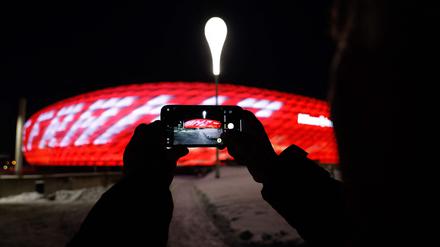 Eine Person fotografiert mit einem mobilen Gerät die Allianz Arena, das Stadion des FC Bayern, während die Worte „Danke Franz“ zu Ehren von Franz Beckenbauer auf die Arena projiziert werden. 