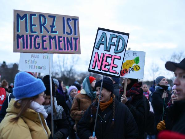 Kritik am CDU-Chef: „Merz ist mitgemeint“ steht in Berlin auf einem Plakat (21.01.2024). Daneben ein Pappschild mit der Aufschrift „AfD Nee“.