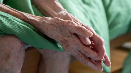 Eine pflegebedürftige Seniorin sitzt auf ihrem Bett. Die Ermittlungen gegen Mitarbeiter eines Pflegedienstes in Berlin geben laut Berliner Gesundheitsverwaltung keinen Anlass zur allgemeinen Sorge.