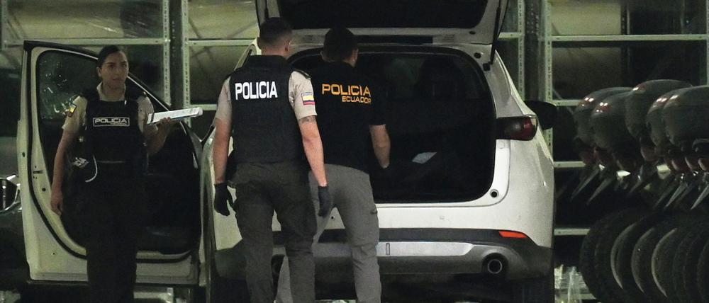 Polizisten in Schutzwesten untersuchen das Auto des erschossenen Staatsanwalts César Suárez in Guayaquil.