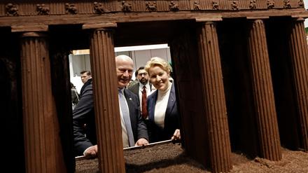 Kai Wegner (CDU), Regierender Bürgermeister von Berlin, und Franziska Giffey (SPD, r), Berliner Wirtschaftssenatorin, schauen beim Eröffnungsrundgang über das Messegelände der Grünen Woche in der Berlin Halle durch ein großes Brandenburger Tor aus Schokolade. 