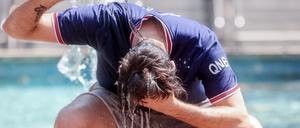 Ein junger Mann übergießt sich mit einer Wasserflasche, um die Hitze zu bekämpfen. Der vergangene Sommer ist nach Auswertungen des EU-Klimawandeldienstes Copernicus der wärmste bisher gemessene in Europa gewesen. 