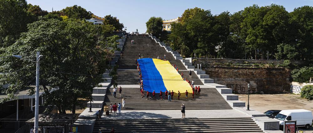 Auf der Potemkinschen Treppe in Odessa tragen Kinder die Ukrainische Flagge die Treppe hinauf.