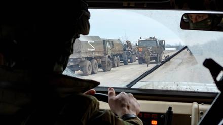 Soldaten eskortieren einen russischen Hilfskonvoi mit Lebensmitteln, die von der Krim in die Ukraine nach Charkiw geschickt werden.