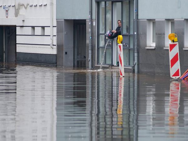 In Flensburg in der Wilhelmstraße im Stadtteil Jürgensby schöpft eine Person Wasser aus einem Gebäude.