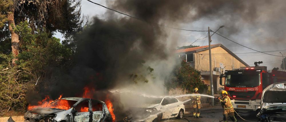 Nach einem Raketenangriff aus Gaza löschen Feuerwehrleute ein brennendes Auto  in Ashkelon im Süden Israels.