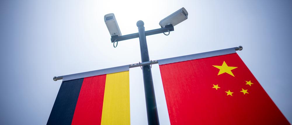 Überwachungskameras sind über der deutschen und der chinesischen Flagge vor der Tongji-Universität montiert.