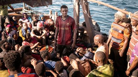 Der furchtlose Seydou (Seydou Sarr, stehend mitte) übernimmt in dem Flüchtlingsboot das Ruder. 