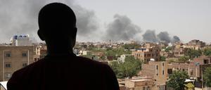 Ein Mann blickt auf die Stadt Khartum, wo schwarzer Rauch aufsteigt. Die Kämpfe in der Hauptstadt zwischen der sudanesischen Armee und den Rapid Support Forces gehen weiter.
