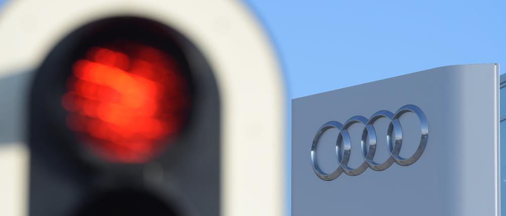 Eine Ampel leuchtet vor der Konzernzentrale des Autoherstellers Audi rot. 