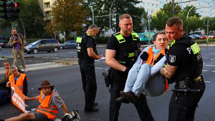 Beamte tragen in Friedrichshain einen Aktivisten von der Straße.