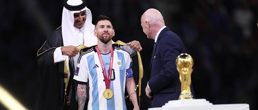 Der katarische Emir Tamim bin Hamad Al Thani streift Argentiniens Kapitän Lionel Messi einen Bischt über.