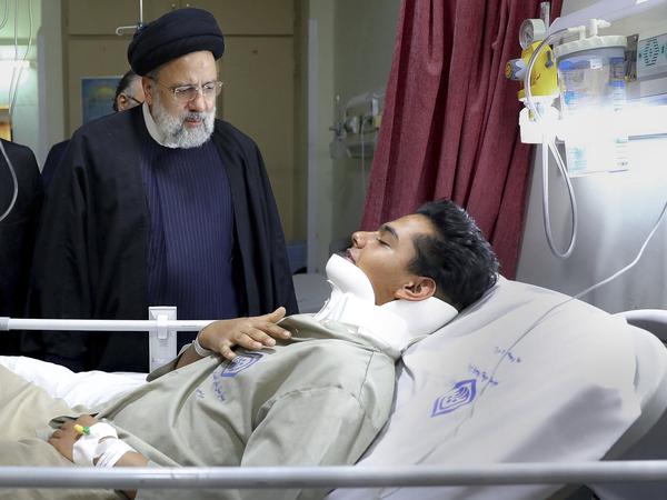 Auf diesem vom iranischen Präsidialamt zur Verfügung gestellten Foto besucht Ebrahim Raisi, Präsident des Iran, einen Mann, der während des Anschlags verletzt wurde. 