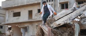 Ein Retter arbeitet an einem beschädigten Gebäude in Darna, Libyen. Nach Angaben des UN-Nothilfebüros (OCHA) kamen allein in der stark zerstörten Hafenstadt Darna rund 11.300 Menschen ums Leben. 