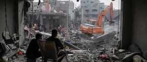Ein Bagger arbeitet an zerstörten Gebäuden nach israelischen Luftangriffen im Gazastreifen. 