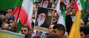 Demonstranten im Iran halten ein Porträt des geistlichen Führers Ali Chamenei hoch.