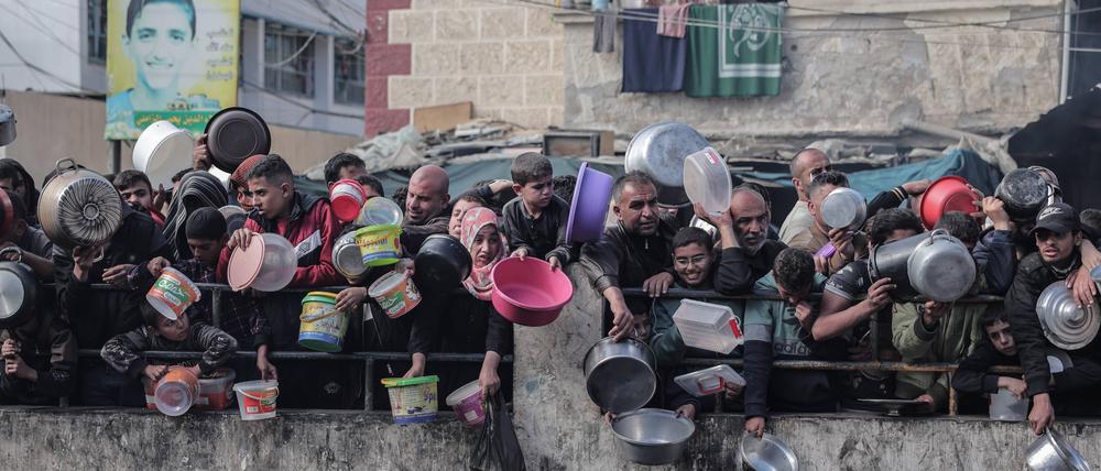 Palästinenser warten in der Grenzstadt Rafah auf die Verteilung von Hilfsgütern.