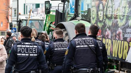 Polizisten gehen während einer Demonstration vor Beginn des politischen Aschermittwochs der baden-württembergischen Grünen vor der Stadthalle in Biberach an der Riß.