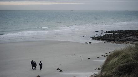 Frankreich, Wimereux: Polizisten suchen an einem Strand nach Migranten. Bei der versuchten Überquerung des Ärmelkanals sind fünf Menschen ums Leben gekommen.