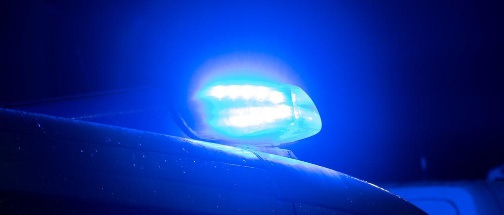 Ein Blaulicht leuchtet auf dem Dach eines Polizeiwagens. 