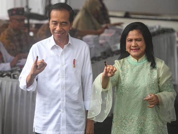 Indonesiens Präsident Joko Widodo und First Lady Iriana zeigen ihre eingefärbten Finger nach der Stimmabgabe in einem Wahllokal. 