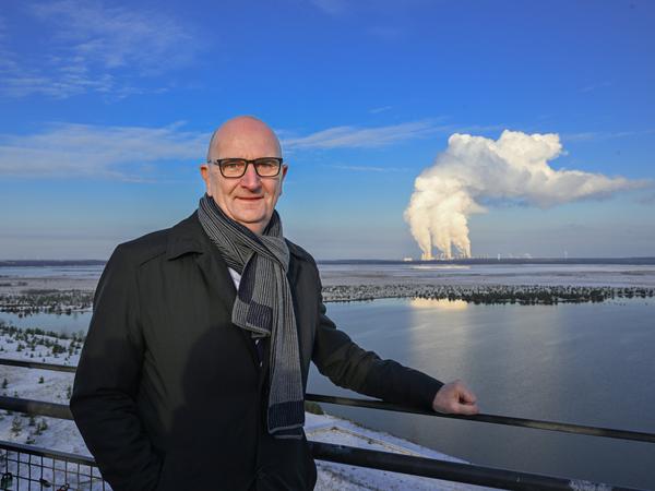 Dietmar Woidke (SPD), Ministerpräsident von Brandenburg, steht auf dem Aussichtsturm am Rand der Cottbuser Ostsee vor der Kulisse des Kraftwerkes Jänschwalde. 