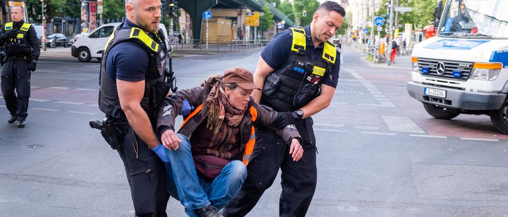 Berliner Polizisten tragen einen Klimaaktivisten von der Straße.